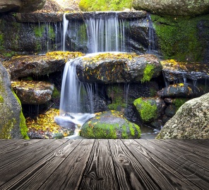 Мостик у водопада с зелёными камнями