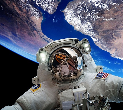 Астронавт в космосе на фоне Земли