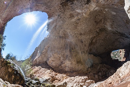 Солнечный свет в пещере с водопадом